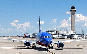 A photograph of a Denver Airline airplane on the runway on a clear day