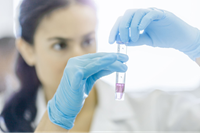 Student in chemistry lab, inspecting a test tube.