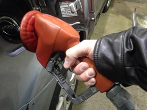 A picture of a person filling their car with gasoline at a pump.