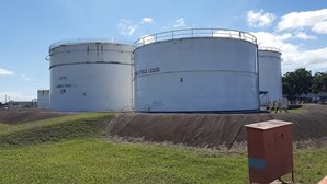 A photograph of large cylinder styled storage tanks on a plot of land.